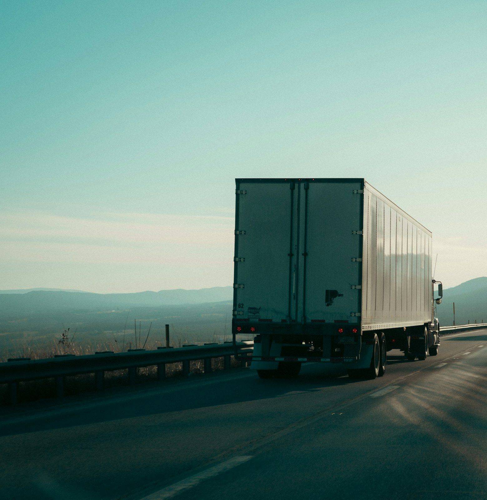 Camion pe autostradă la amurg, văzut din spate